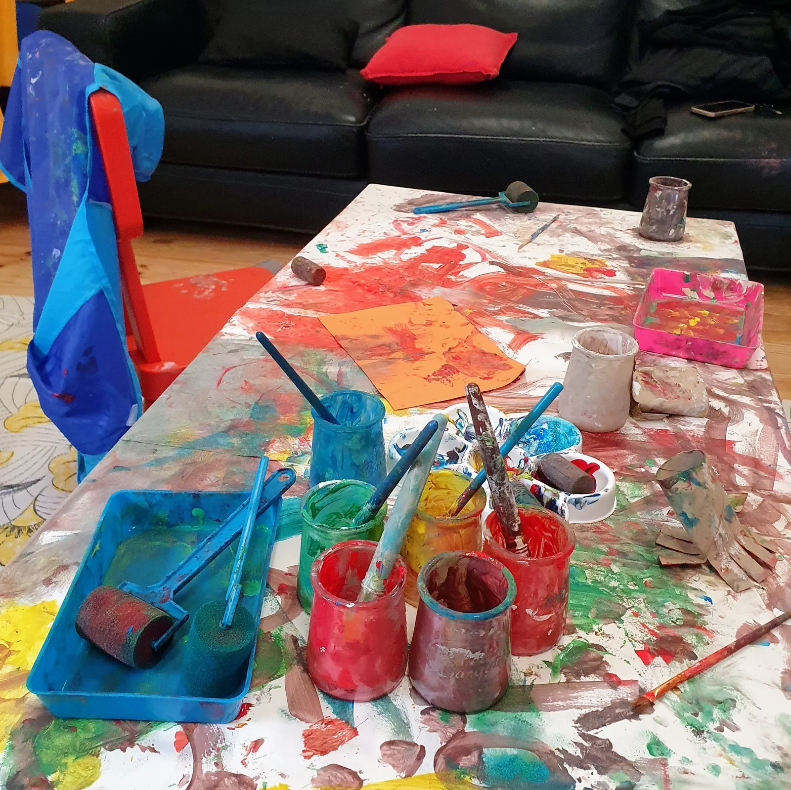 Table d'atelier peinture avec pots, rouleaux et pinceaux