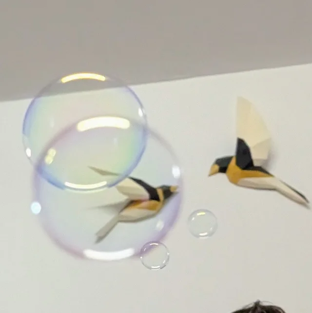 Bulles de savon flottant devant des oiseaux en origami suspendus