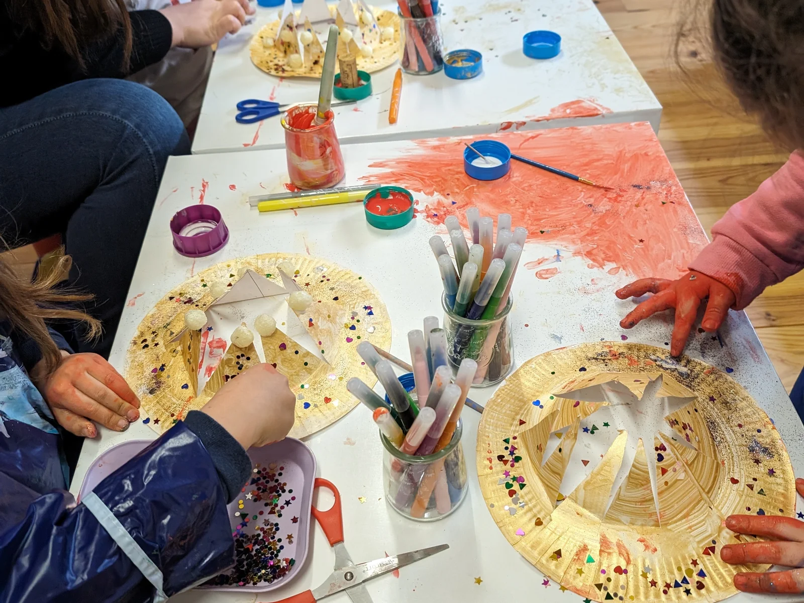 Créations de paillettes et papier crépon sur assiettes en carton